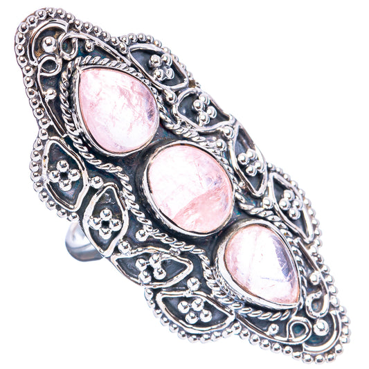 Sterling silver filigree ring with three oval pink gemstones, angled view
