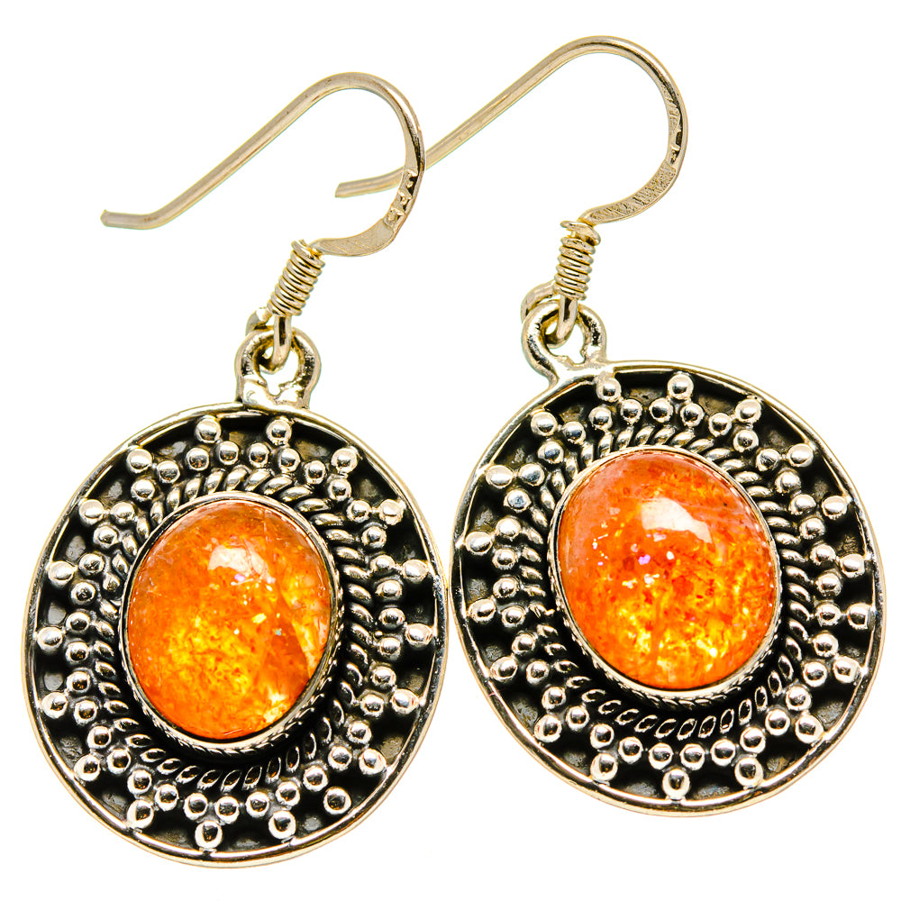 Pair of round sterling silver earrings with orange sunstone cabochon and ornate beading