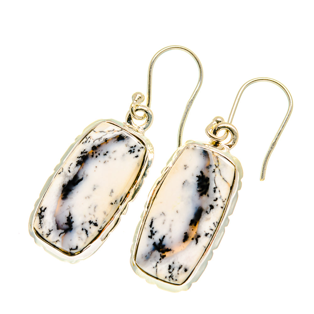 Dendritic opal drop earrings with oval white stones, gold hooks, black dendrite patterns.