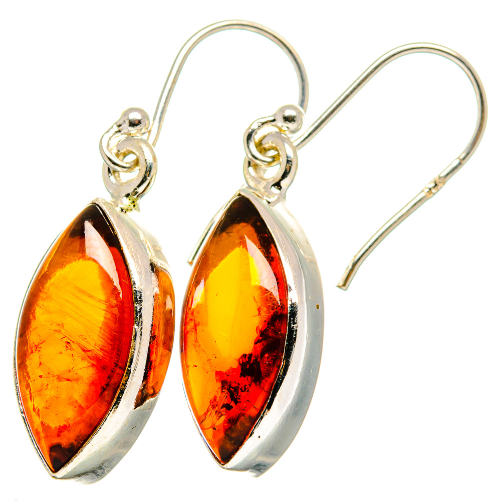 Amber teardrop earrings in sterling silver with warm orange translucent stones and hooks.