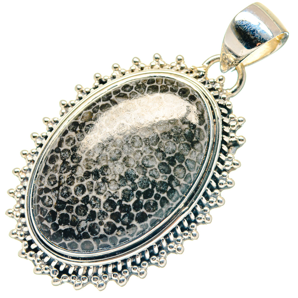 Round silver pendant with textured oval inset, beaded edge, and top bail