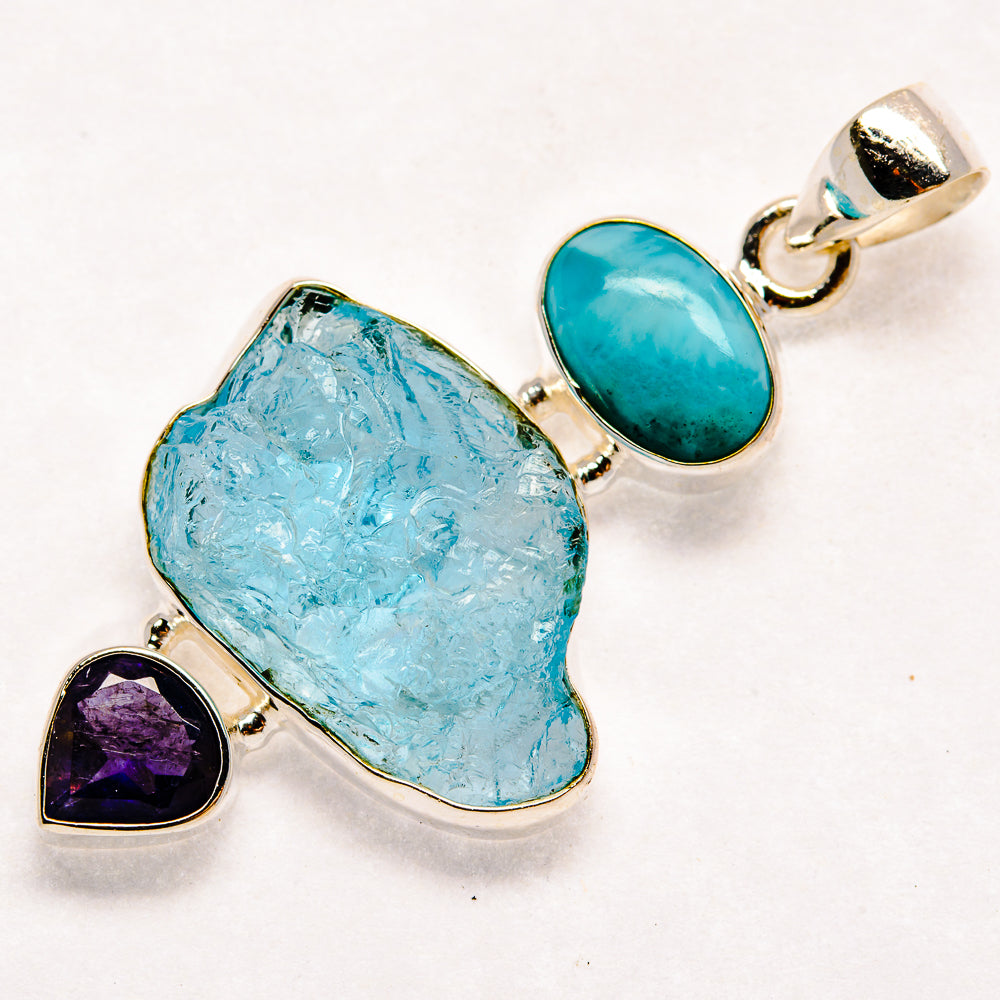 Sterling silver pendant with rough light-blue stone, teal oval top, and heart amethyst