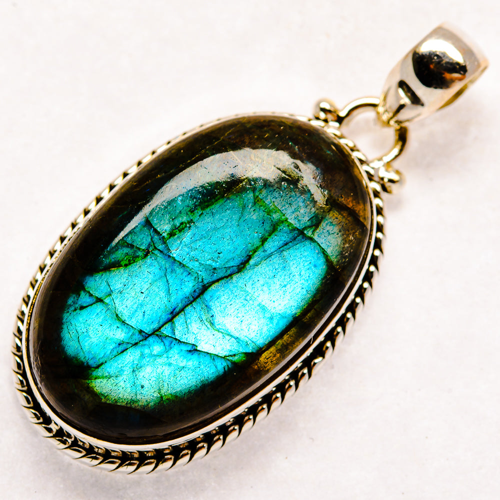 Sterling silver labradorite pendant, oval teal-blue flash stone cabochon with decorative border.