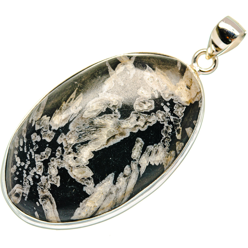 Chrysanthemum stone pendant in oval bezel with black base and silver-like inclusions, bail top