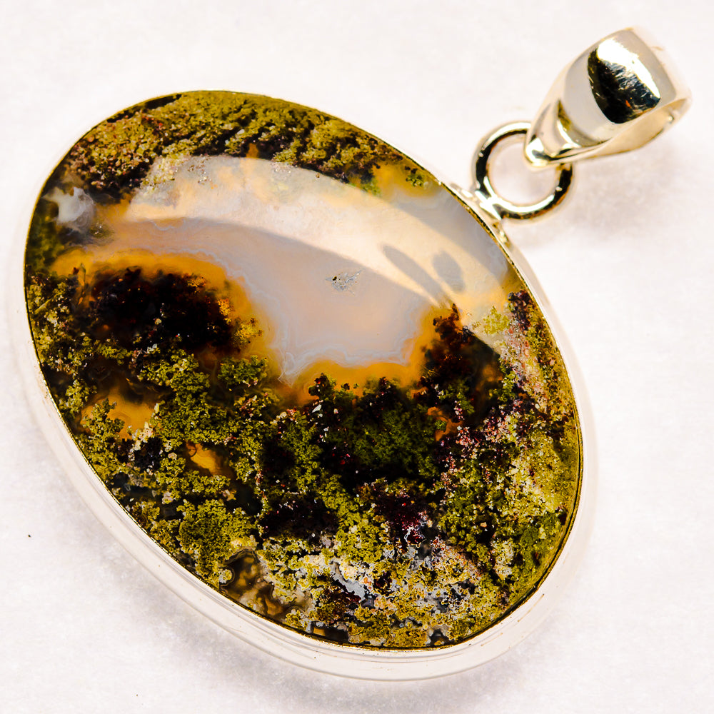 Oval plume agate pendant with yellow-green plume inclusions and silver bail