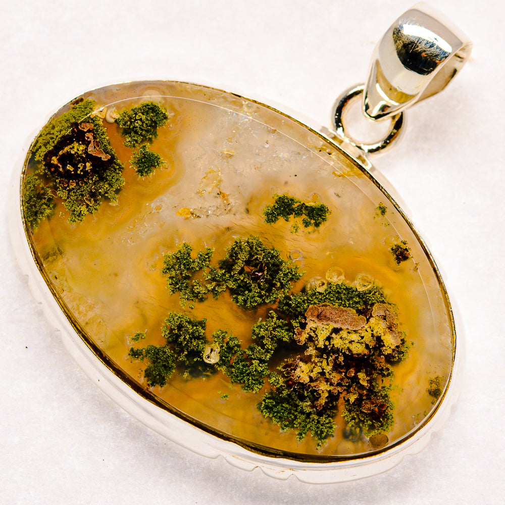 Oval plume agate pendant, yellow-amber stone with green mossy inclusions, silver frame