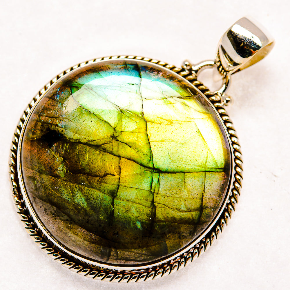 Round labradorite pendant with vivid green flashes in textured silver bezel and bail
