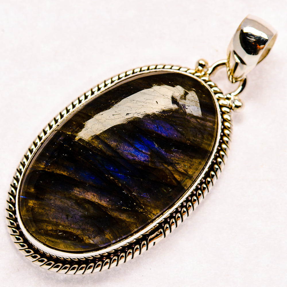 Labradorite pendant with oval dark stone and blue flash, set in 925 sterling silver bezel.