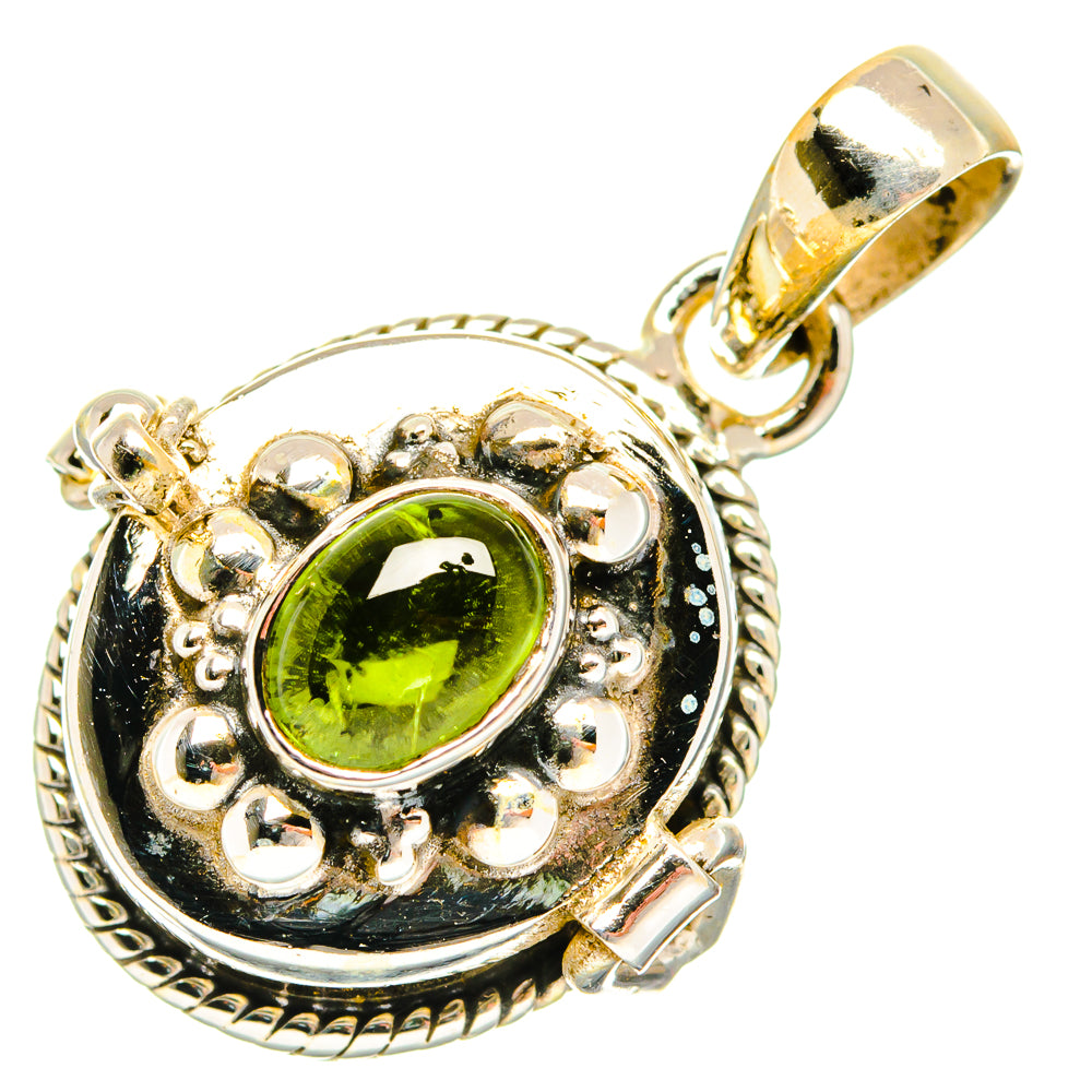 Sterling silver pendant with green oval gemstone in ornate halo bezel.