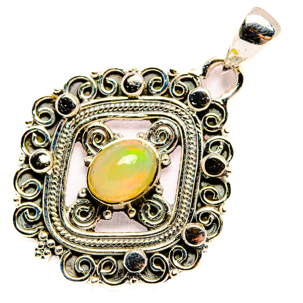 Sterling silver oval opal pendant with ornate filigree border and light opal center