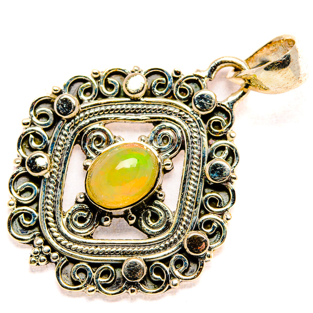 Sterling silver opal pendant with oval green-yellow cabochon, scrollwork frame, and loop bail