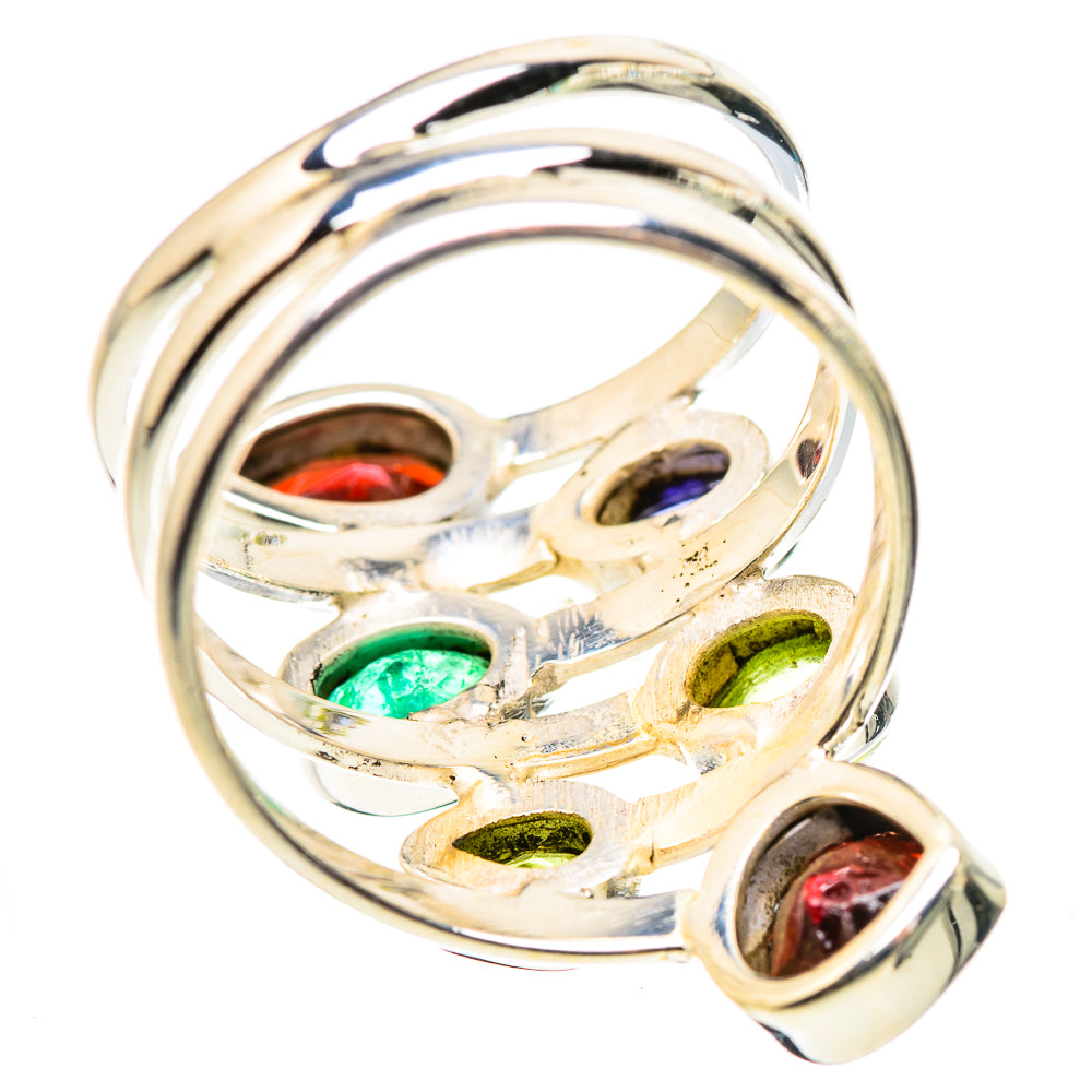 Silver openwork ring with oval gemstones showing red, green, and dark purple stones at angles
