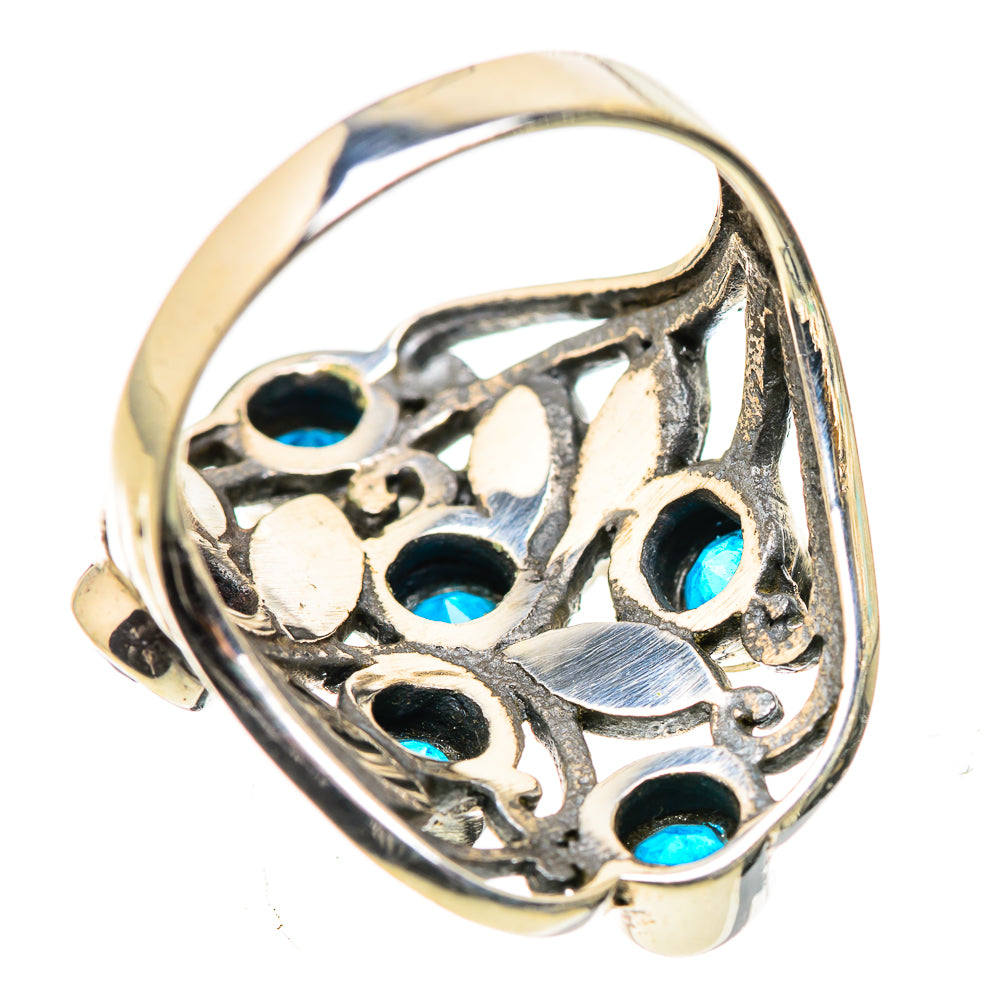 Silver ring with openwork design and round blue gemstones around the band