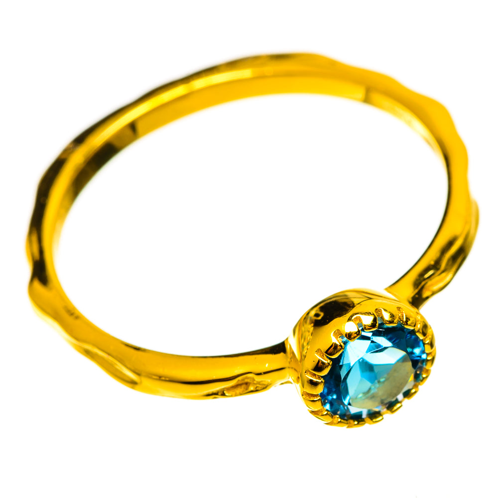 Gold-plated ring with round blue gemstone on twisted band
