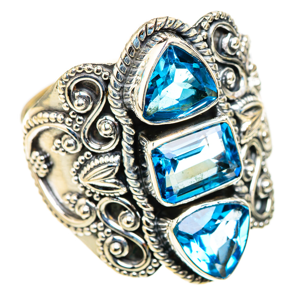 Ornate silver ring with three blue gemstone settings and detailed filigree sides