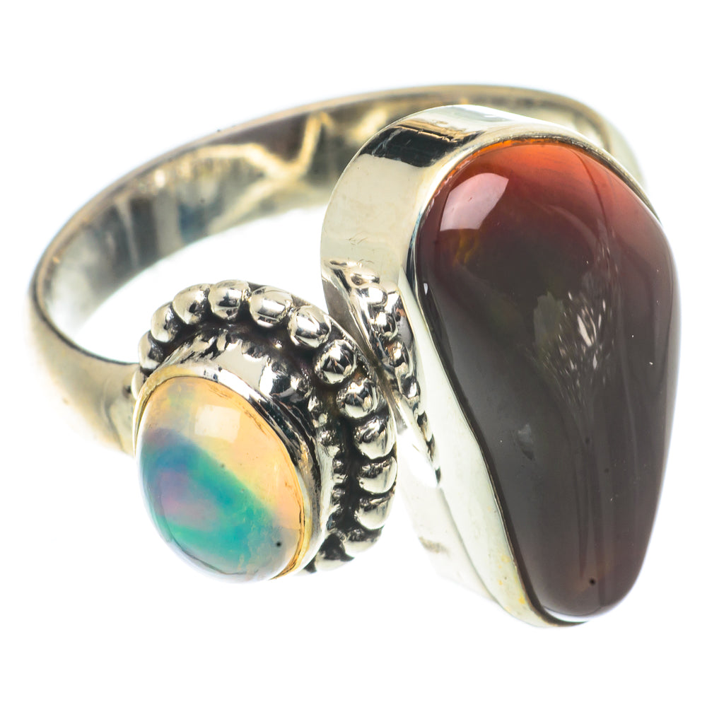 Sterling silver ring with dark red-brown oval cabochon, small blue-green opal bezel.