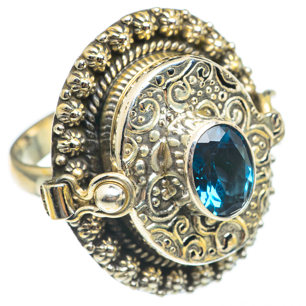 Ornate sterling silver ring with oval blue gemstone and decorative filigree band sides