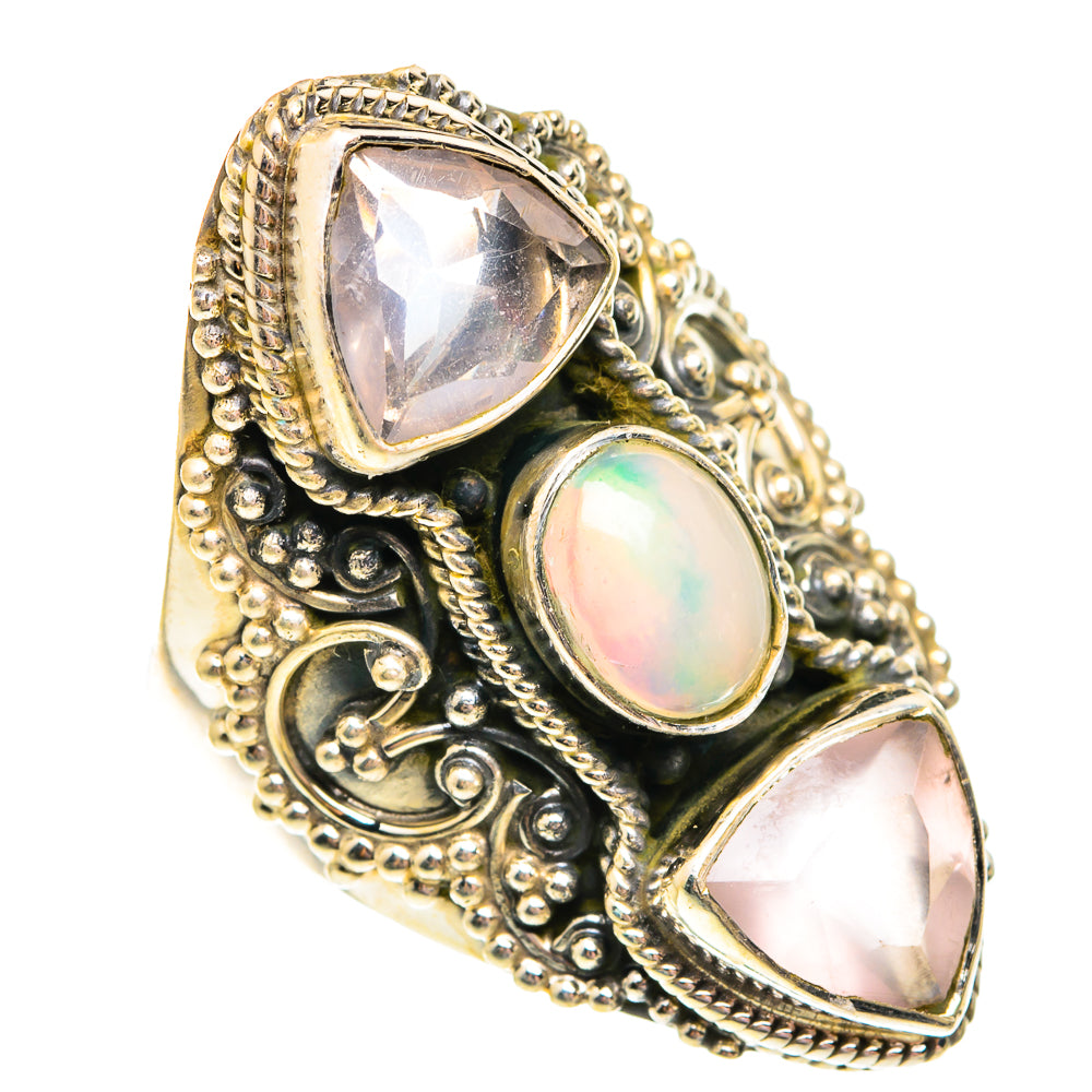 Ornate silver-tone ring with oval opal and three faceted stones in triangular settings