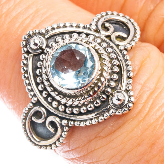 Sterling silver ring with oval blue topaz and ornate bead bezel