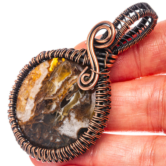 Oxidized copper wire-wrapped tube agate slice pendant with circular frame and bail