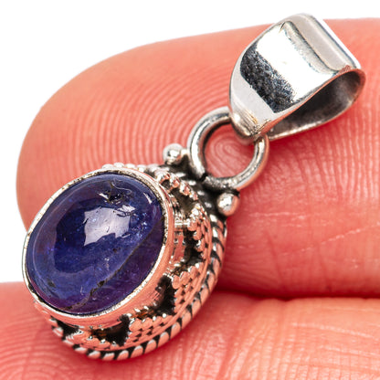 Sterling silver tanzanite pendant close-up, oval blue stone in engraved round setting