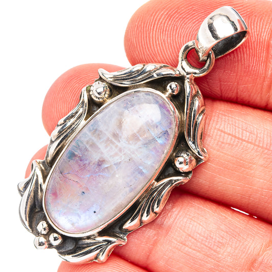 Iridescent moonstone pendant in ornate sterling silver frame, close-up