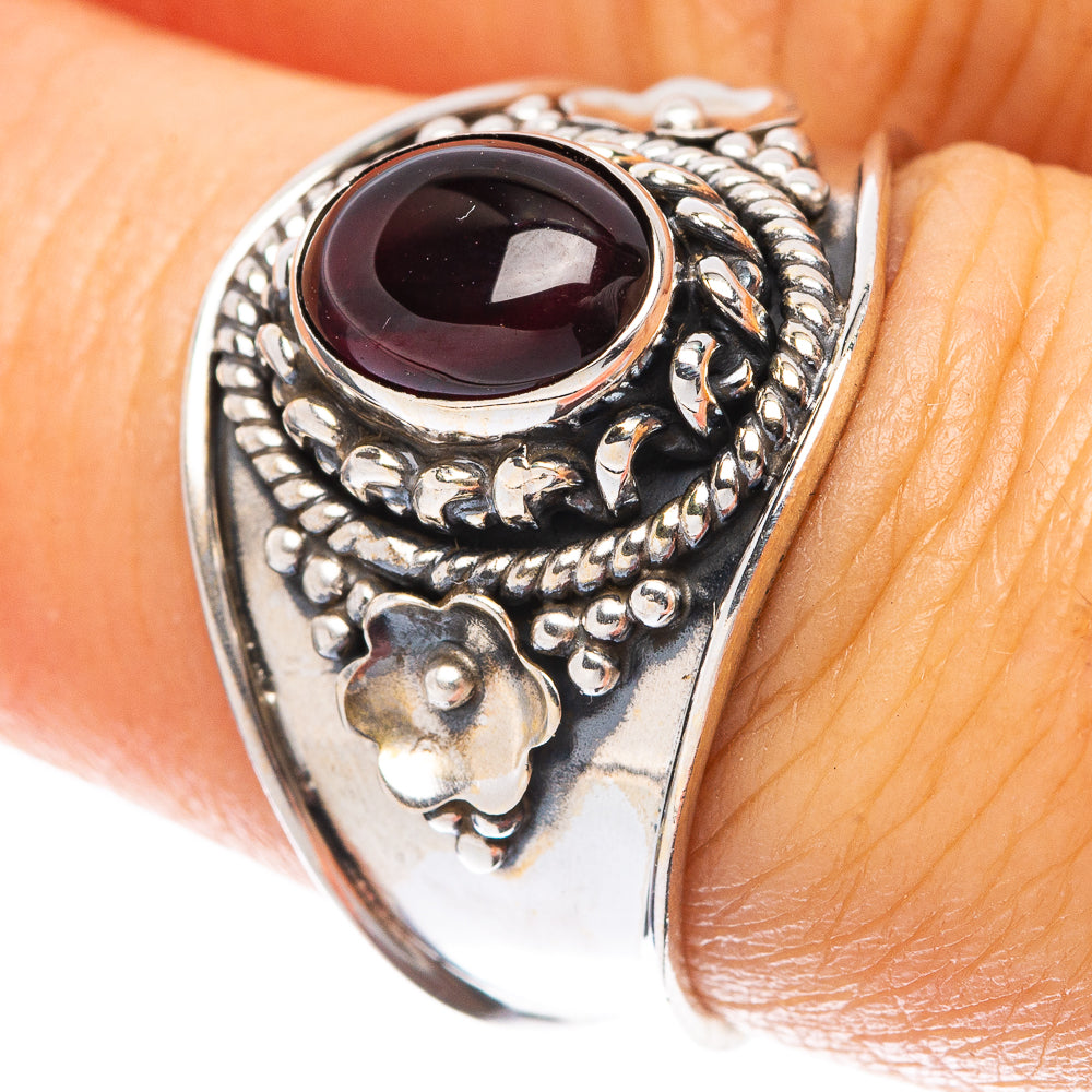 Sterling silver ring with dark oval gemstone and ornate floral filigree, size 7