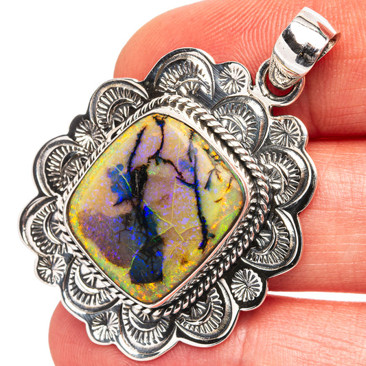 Sterling silver opal pendant with ornate scalloped bezel and blue-purple rainbow stone