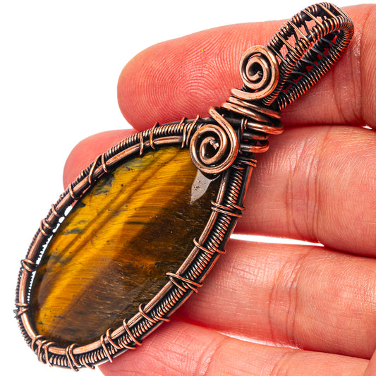 Oxidized copper wire-wrap pendant with round tiger’s eye stone and spiral wire details