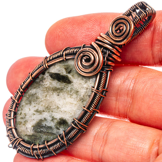 Oxidized copper wire-wrapped pendant with oval green stone and spiral frame