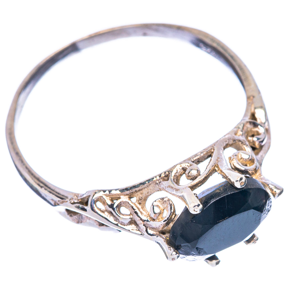 Black onyx ring showing oval dark stone and decorative silver scrollwork