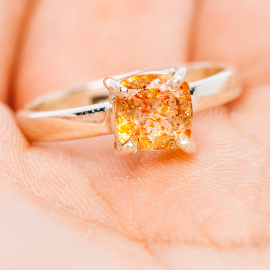 Sterling silver ring featuring faceted orange sunstone in square prongs