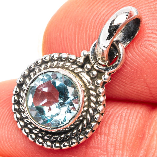 Blue topaz pendant, .925 sterling silver with ornate round bezel and bail, close-up.