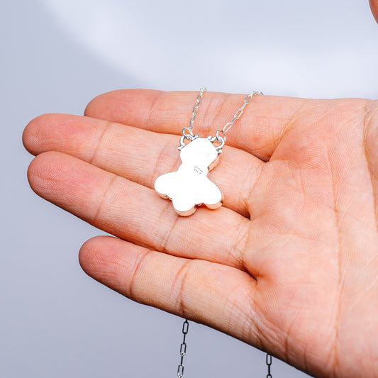 Sterling silver necklace on hand with white floral pendant, 16–18 in