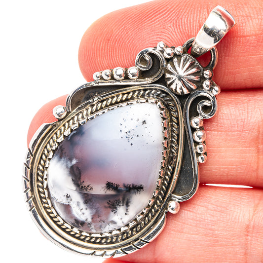 Oval sterling silver dendrite opal pendant with ornate frame and bail, hanging loop