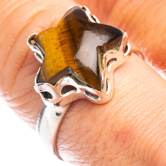 Tiger's-eye star ring close-up on finger, sterling silver claws on brown-gold stone