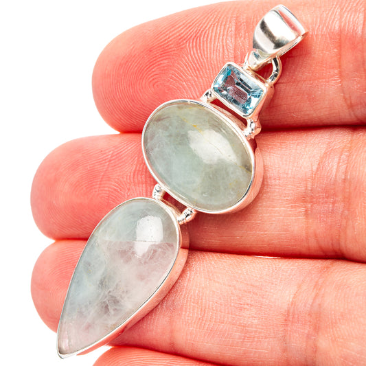 Sterling silver pendant with two light blue cabochon stones and a small blue topaz accent