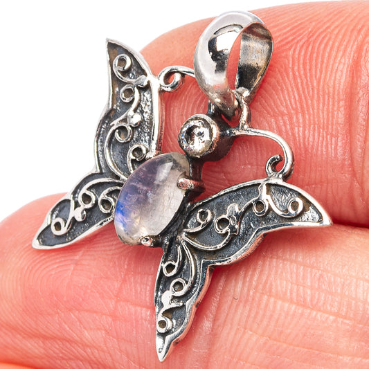 Sterling silver butterfly pendant close-up with round iridescent moonstone and filigree wings