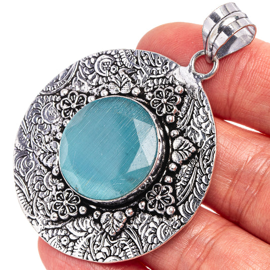 Round German silver pendant with ornate floral border and blue onyx cabochon.