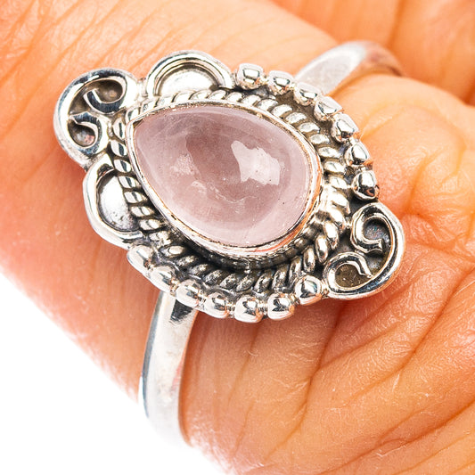 Oval rose quartz cabochon sterling silver ring with ornate rope setting, openwork sides