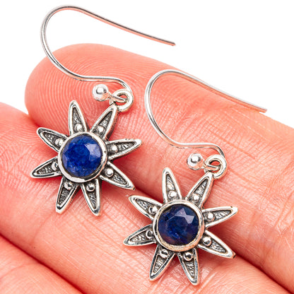 Sterling silver flower drop earrings with round blue gemstone centers, close-up detail