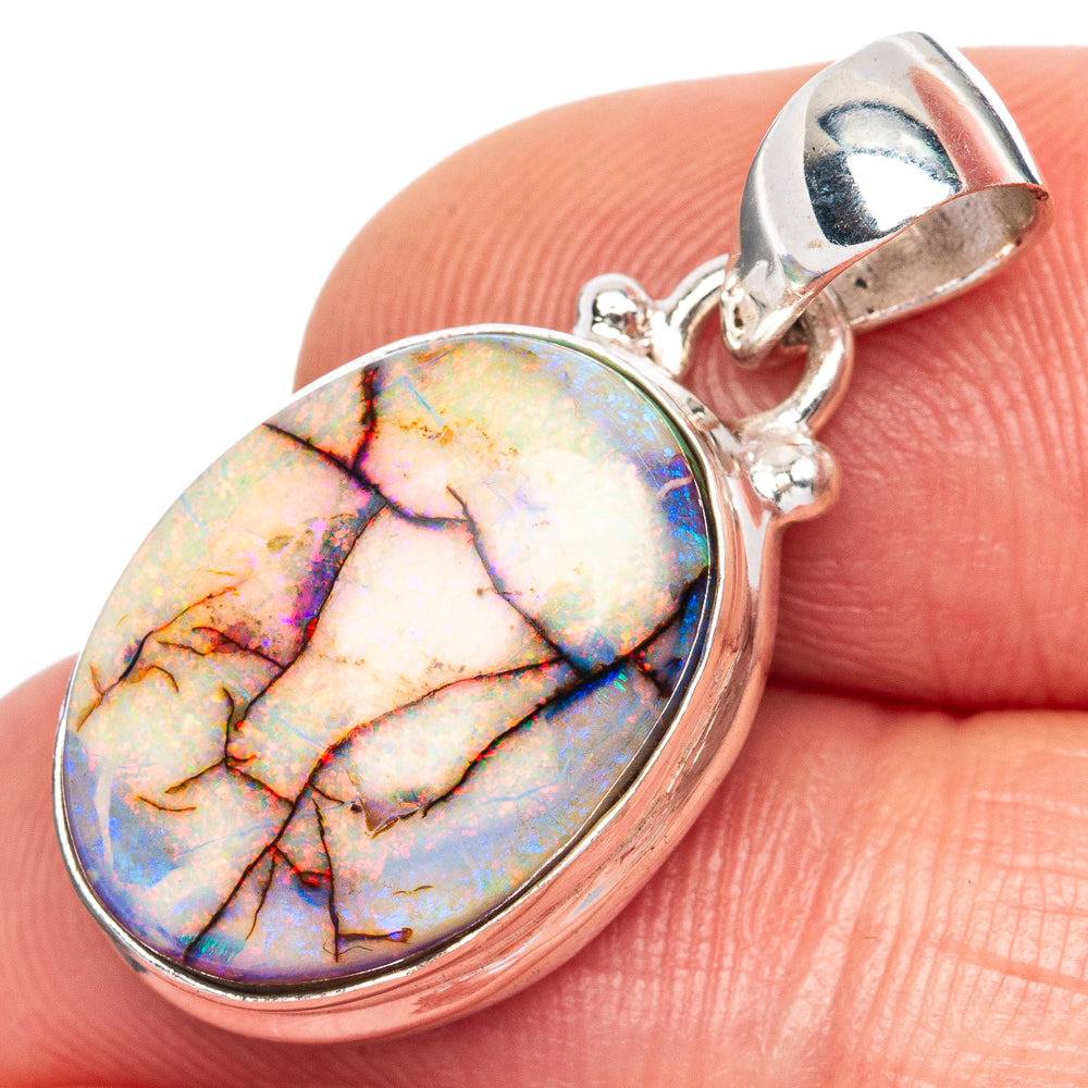 Oval opal pendant in silver bezel with open-back bail and faceted rainbow coloring