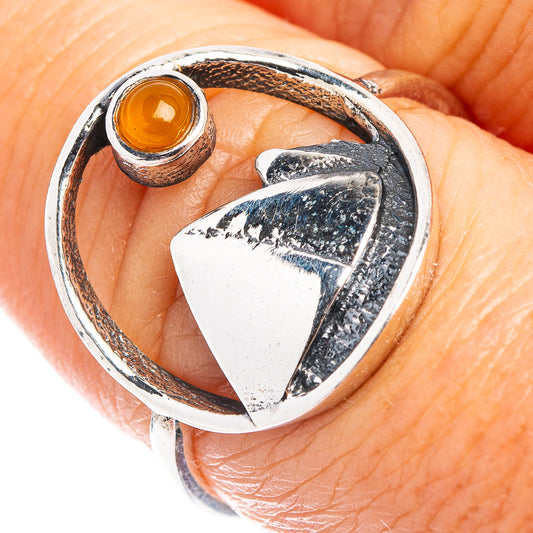 Sterling silver ring detail with round orange carnelian stone and textured mountain bezel
