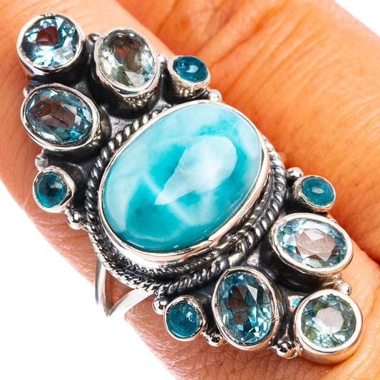 Sterling silver turquoise cabochon ring with surrounding blue stones, worn on hand