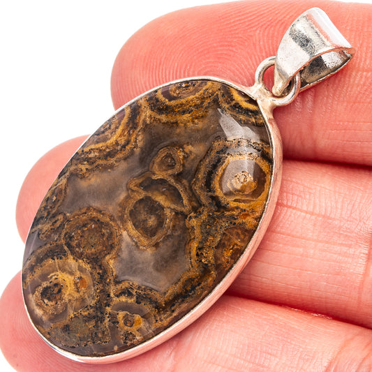 Silver-plated tube agate pendant close-up, oval stone with brown and gray veining.