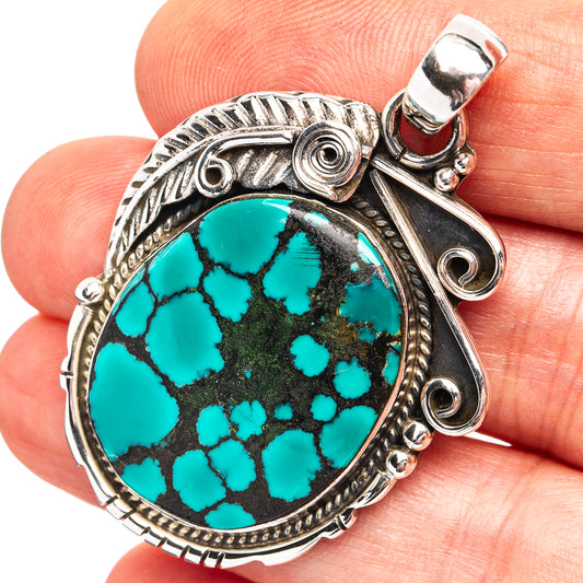 Sterling silver pendant with oval turquoise cabochon and ornate bezel, bail top