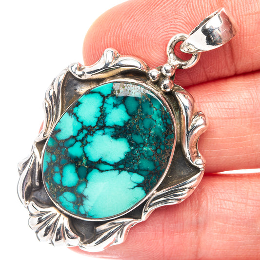 Sterling silver pendant with oval turquoise cabochon and ornate leaf-style frame