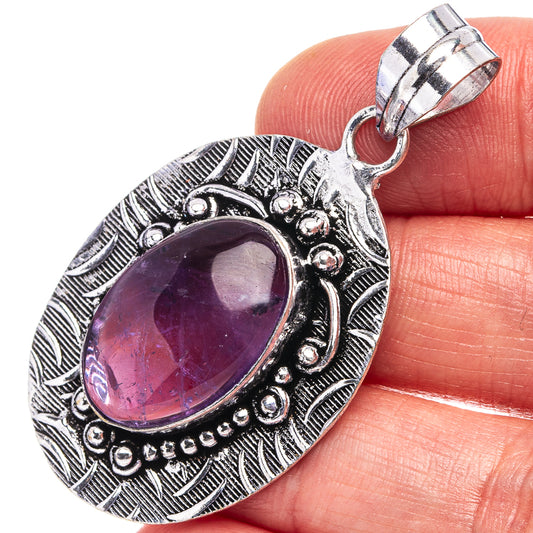 Amethyst stone pendant in German-silver oval setting with ornate border and bail