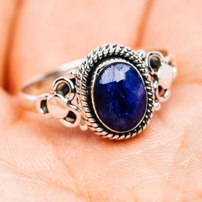 Sapphire dainty ring, oval deep blue gemstone framed by detailed rope-like silver setting