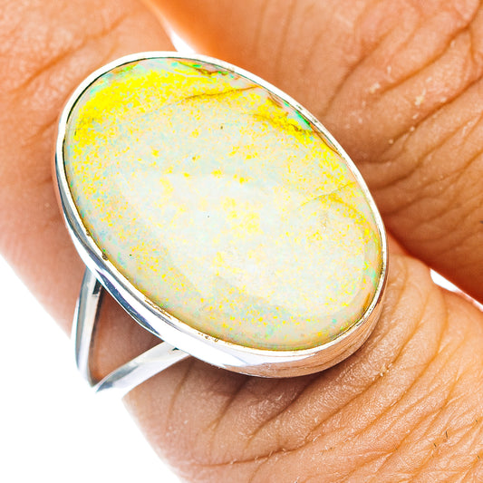 Oval opal cabochon sterling silver ring with yellow and green iridescence, close-up